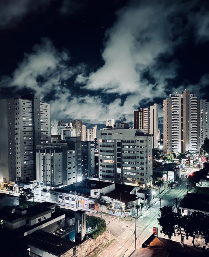 Fortaleza city skyline at night, with residential and commercial tower blocks lit up against a cloudy sky